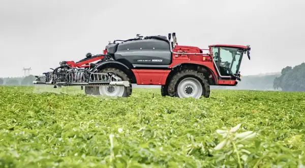 Czerwony opryskiwacz polowy HORSCH LEBB 5.230 VT w akcji na zielonym polu.